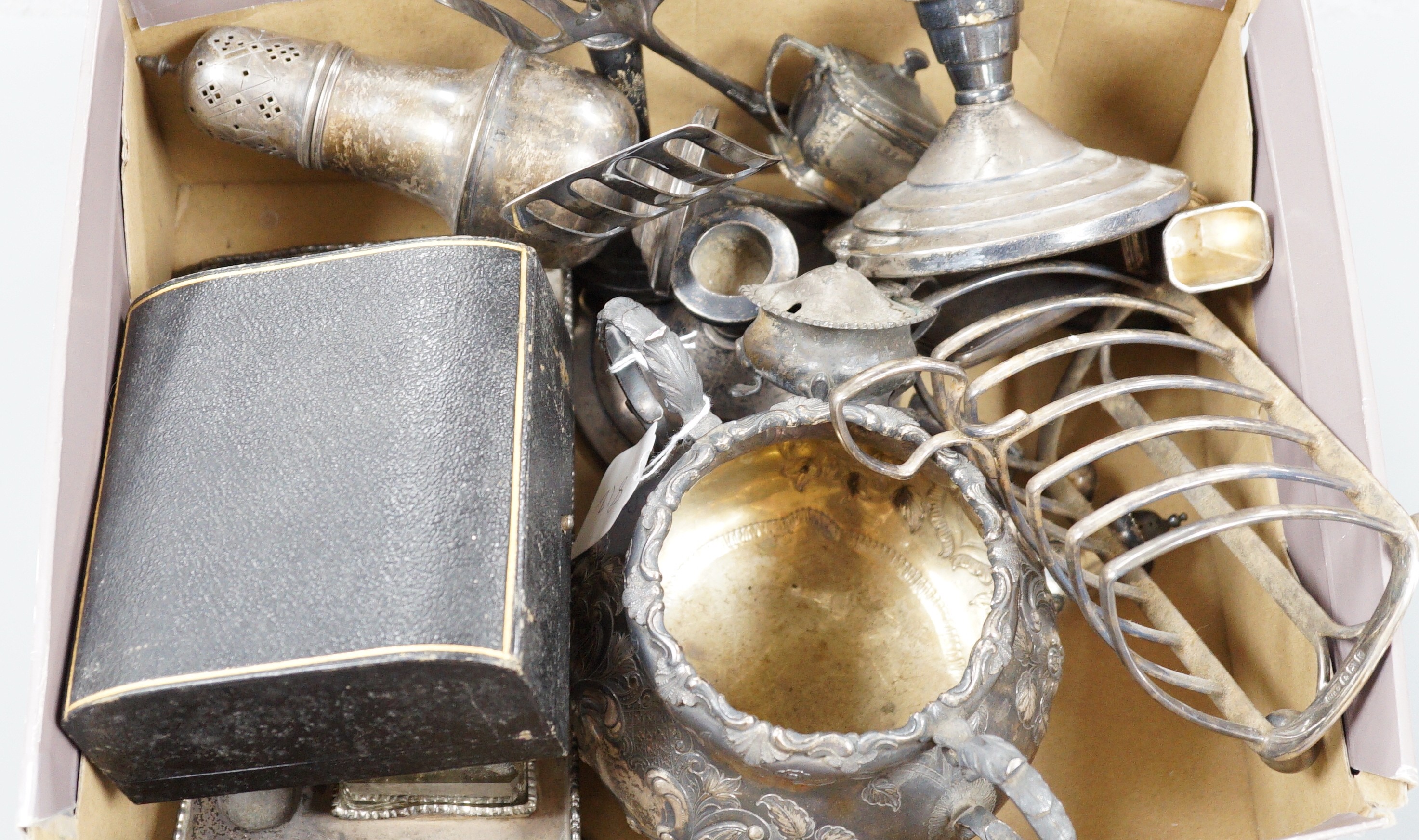 Assorted silver wares to include a George V toast rack, Birmingham, 1934, napkins rings, weighted dwarf candlesticks, cigarette case, condiments, an Edwardian desk stand and a Victorian Irish two handled sugar bowl jar,